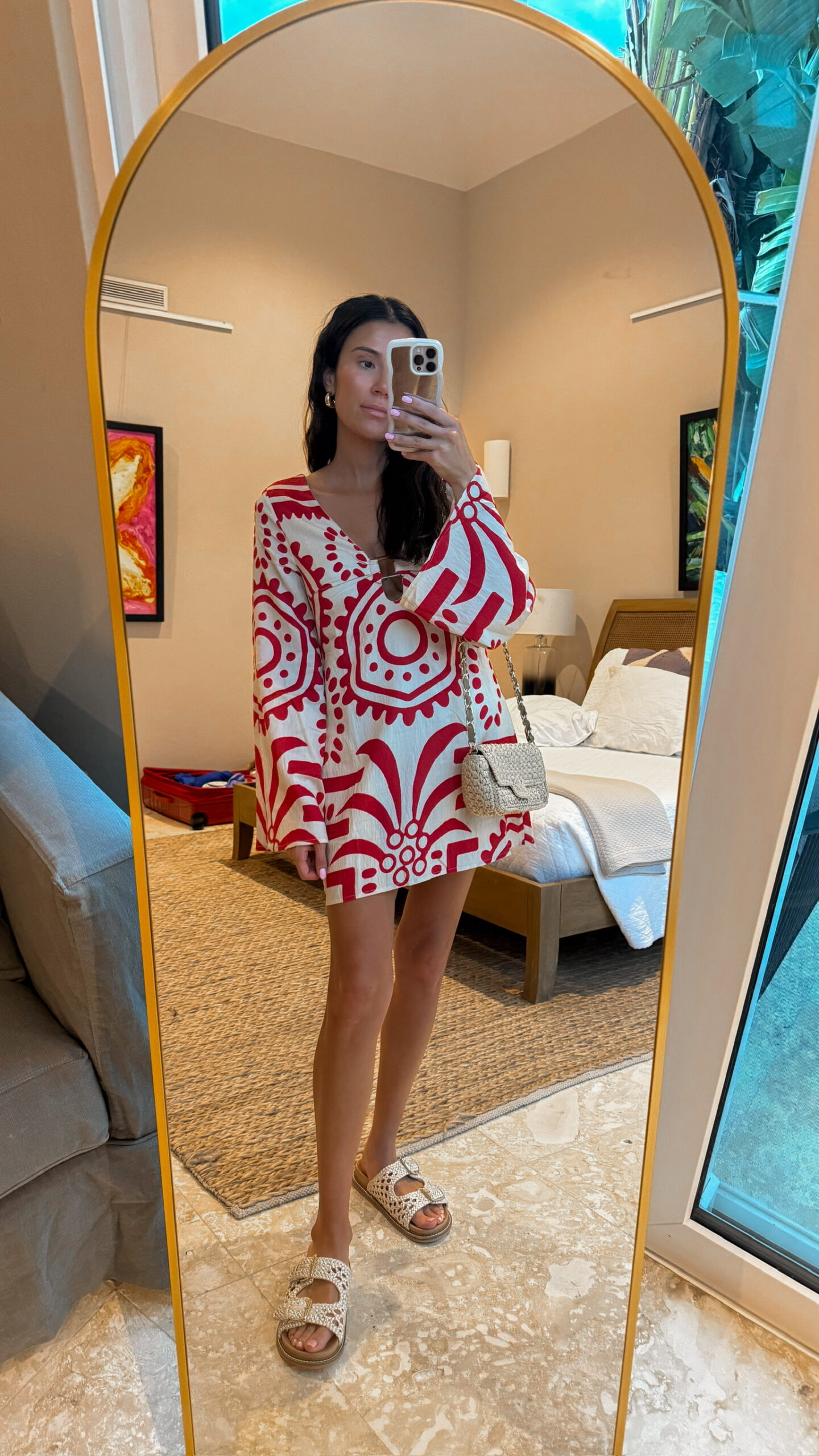 Christine Andrew in short red and white resort wear dress on beach vacation